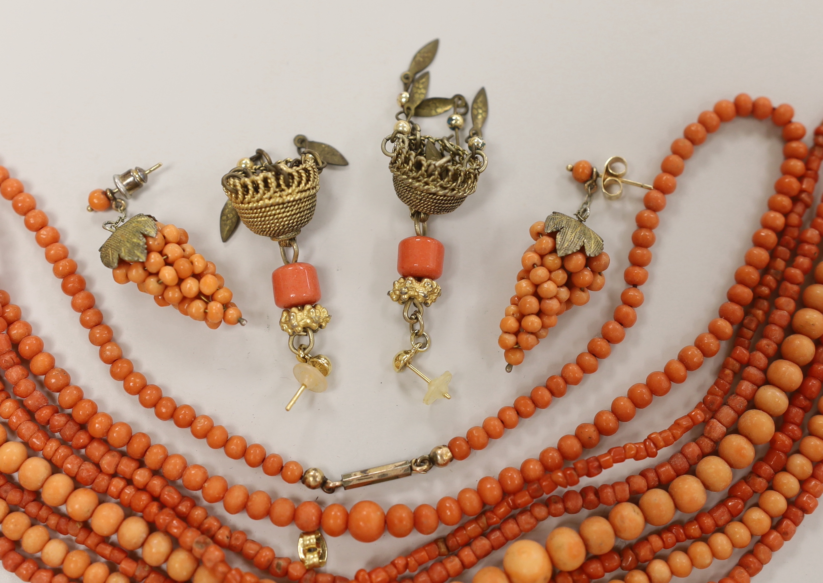 Three coral bead necklaces, largest 110cm and two pairs of earrings including coral cluster modelled as a bunch of grapes.